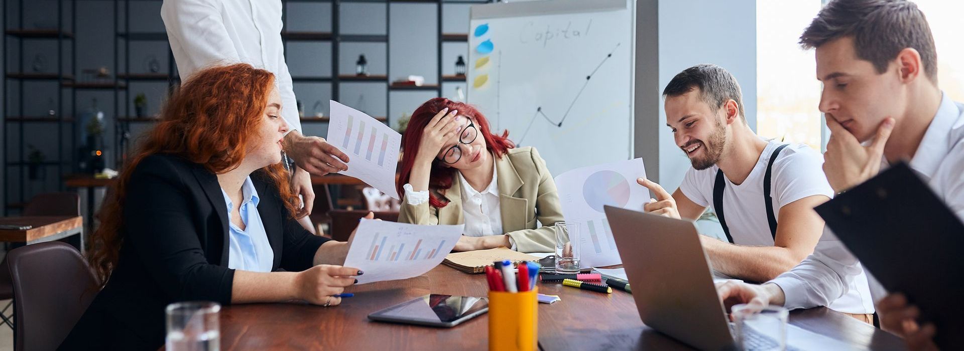 A women is overwhelmed as she sits a meeting where 3 people try to talk to her at once