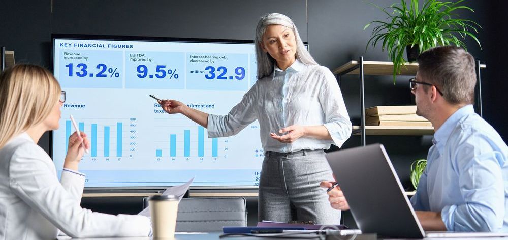A woman is giving a presentation to a group of people in a conference room.