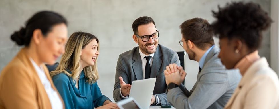 A group of people are sitting around a table having a meeting.