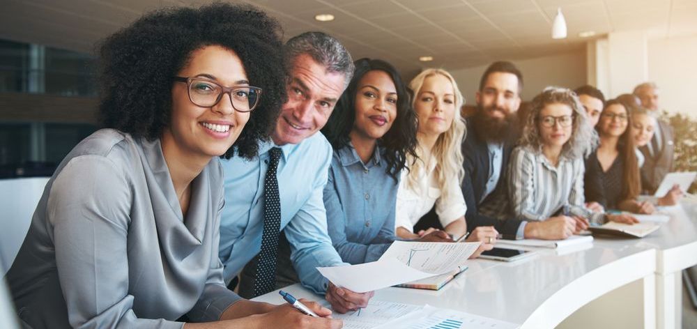 A group of people are sitting at a table in a conference room.