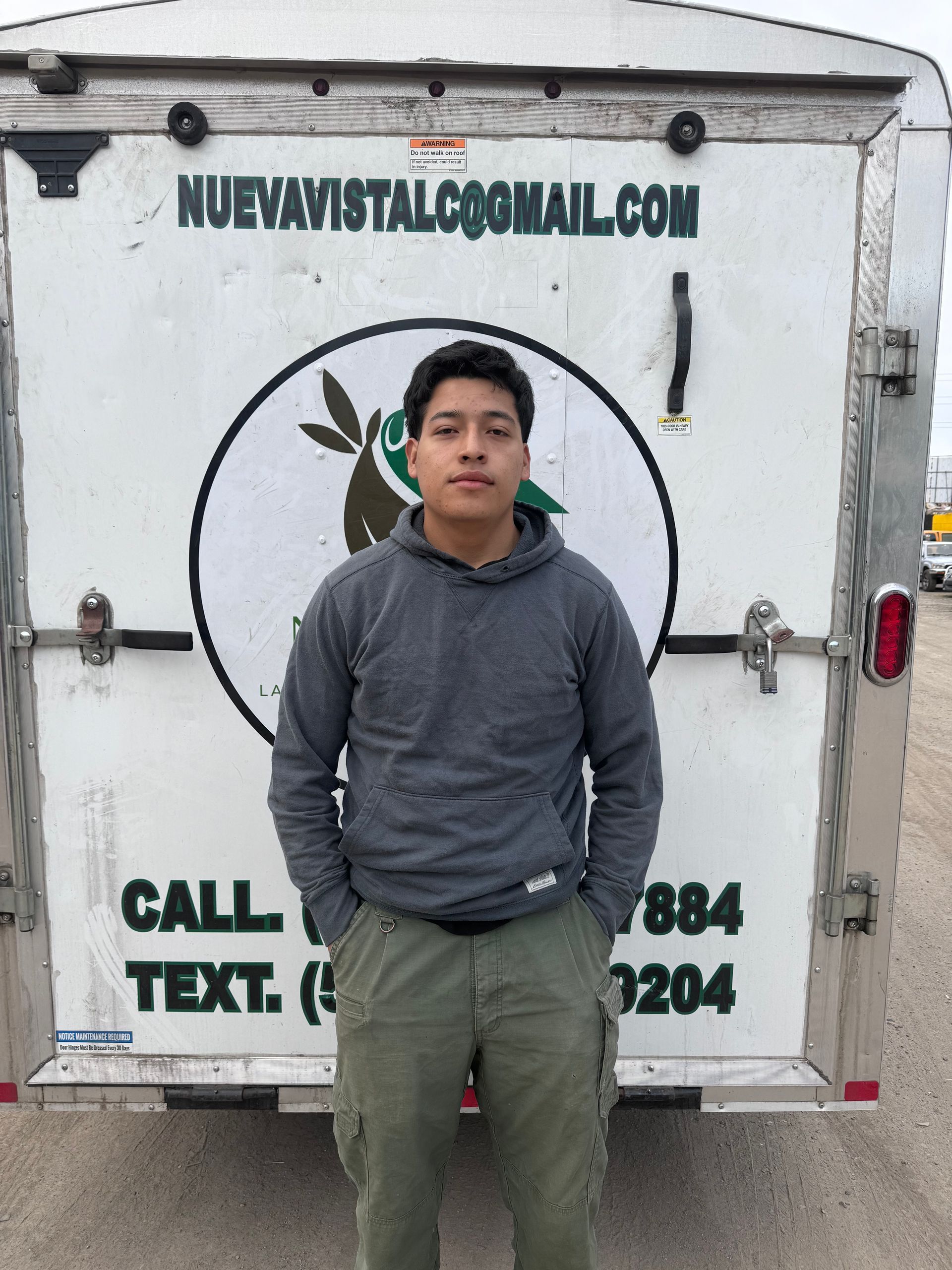 A man standing in front of a trailer that says call text