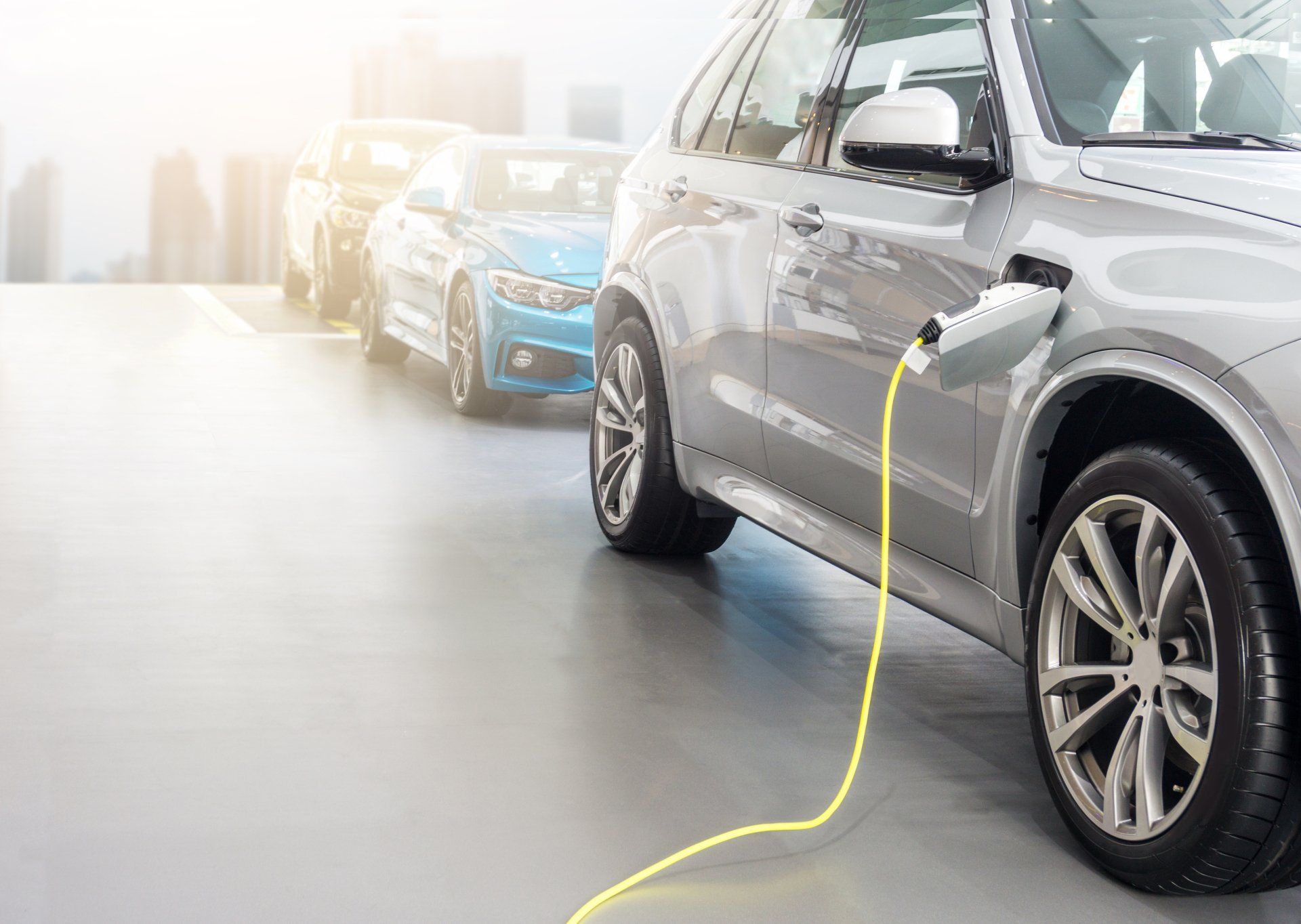 A row of electric cars are being charged in a garage.
