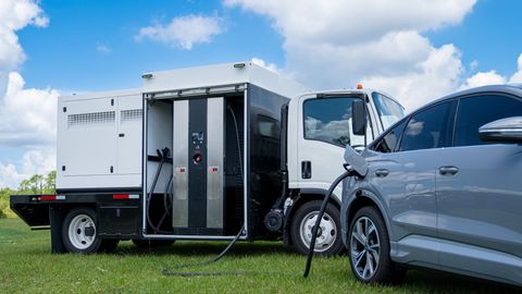 A car is being charged by a truck in a field.
