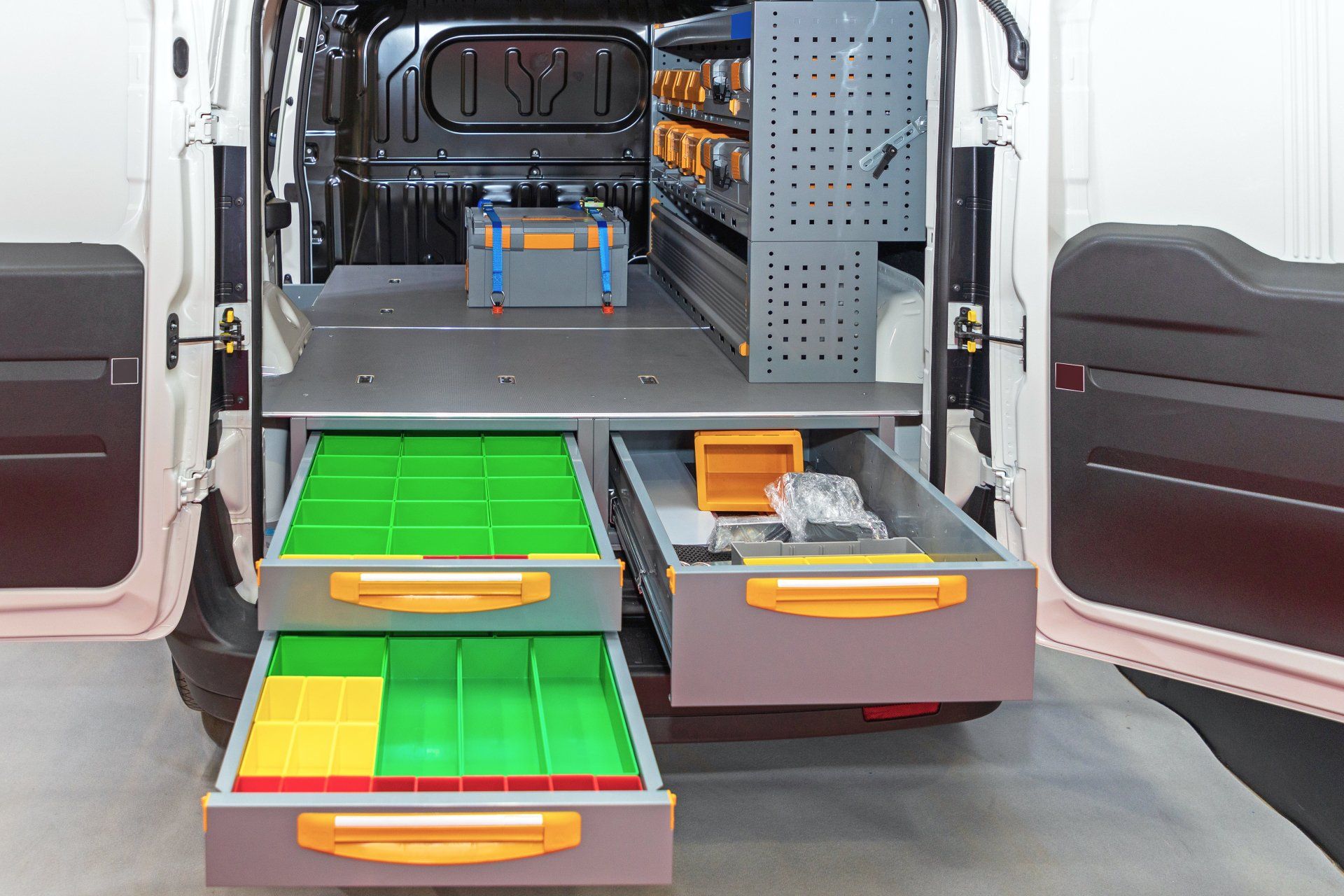 The back of a white van with drawers and shelves.