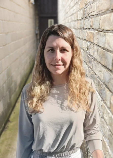Headshot of Ashley in brick alley