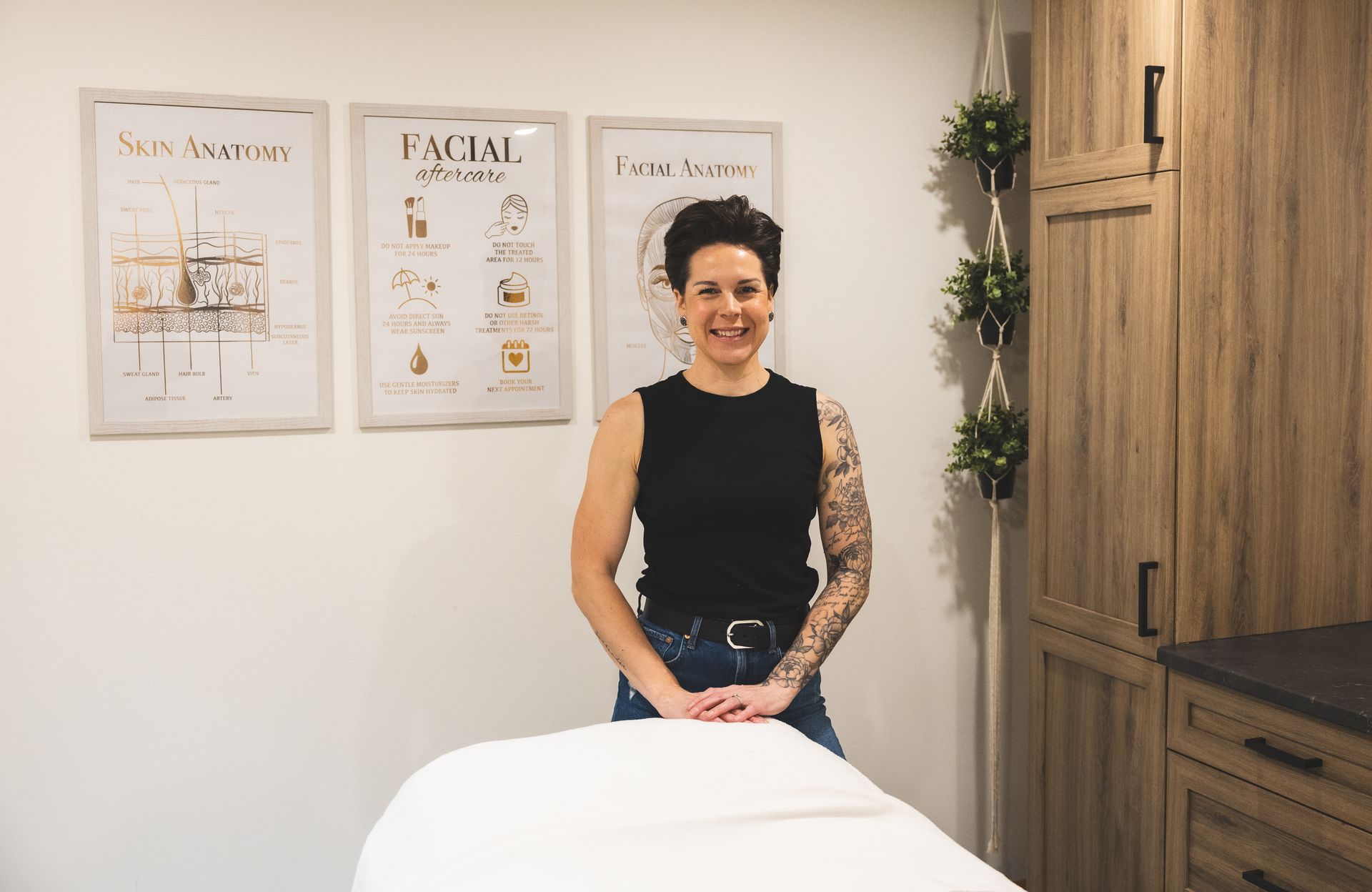 Michelle stands in a bright treatment room beside a massage table.