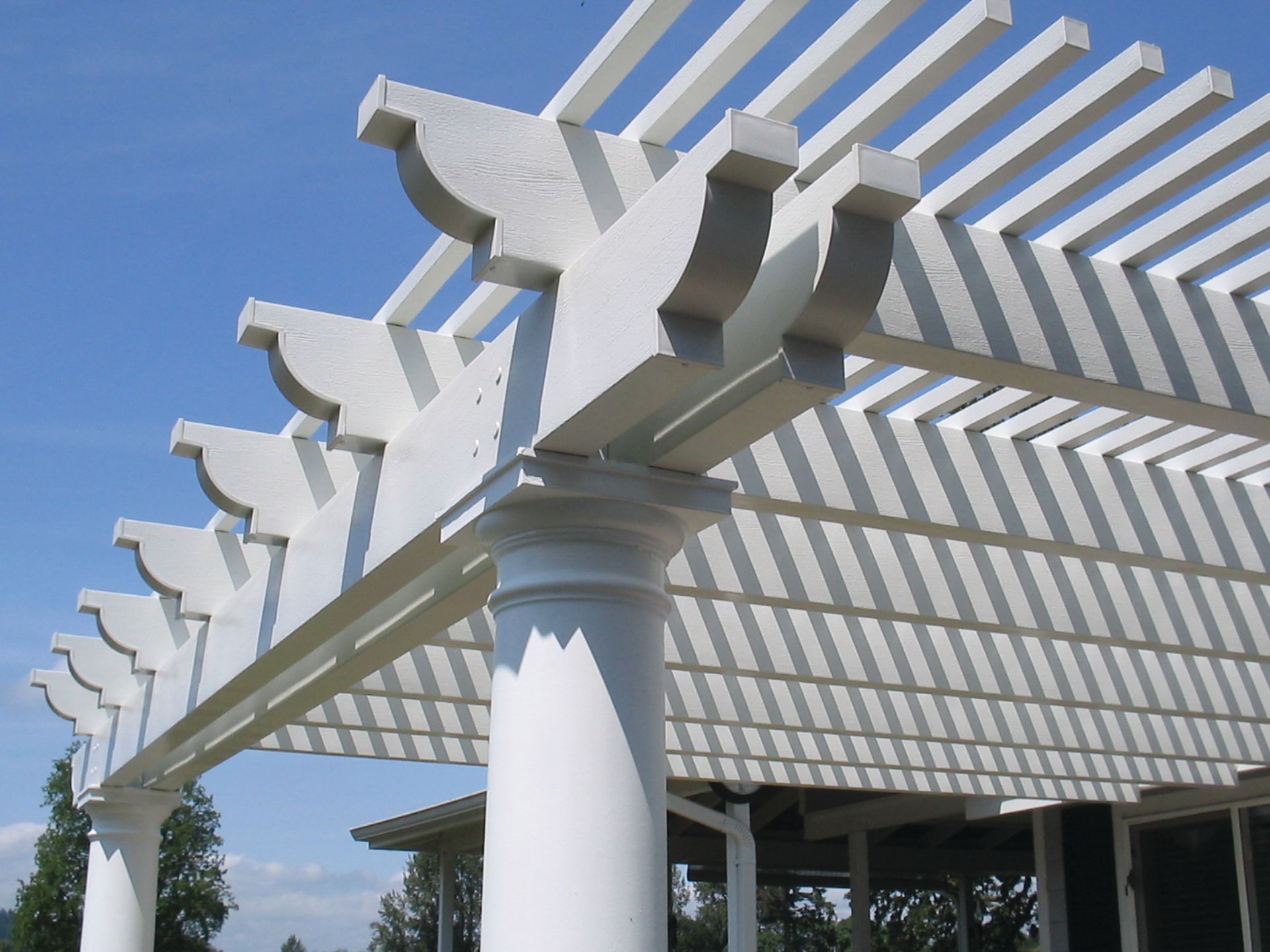 A white pergola with a blue sky in the background