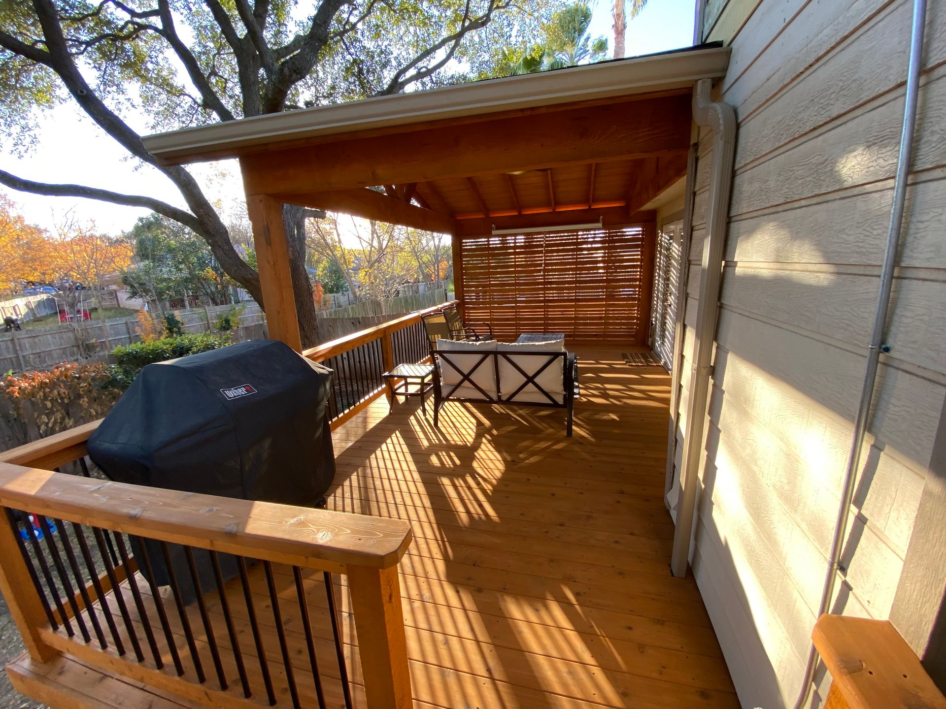 A wooden deck with a grill and a table on it.