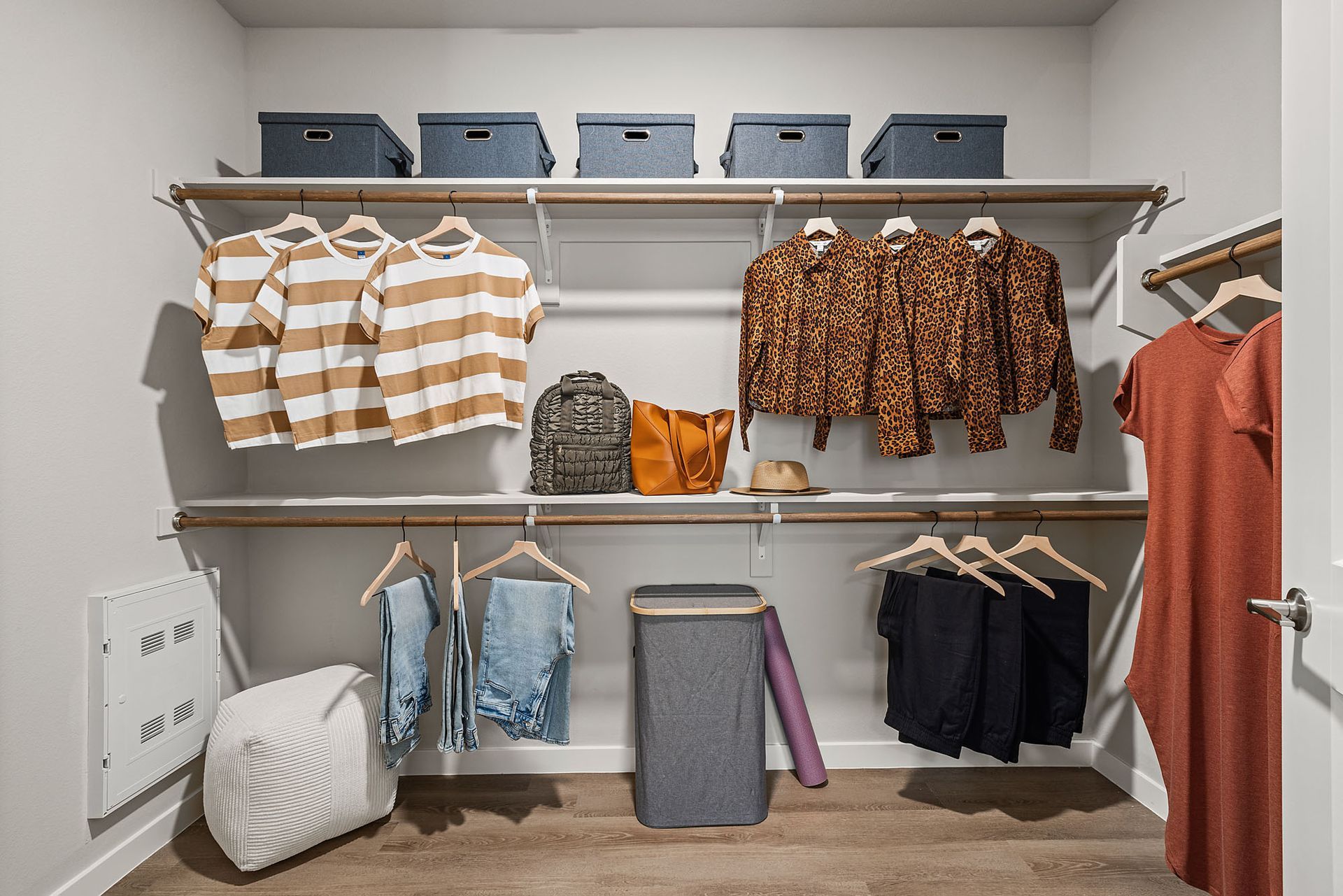 Walk-in closet with clothes hanging on shelves; storage bins on top shelf at Marq Bronco Butte, offers  1, 2, and 3 bedroom apartments in North Valley, Phoenix.