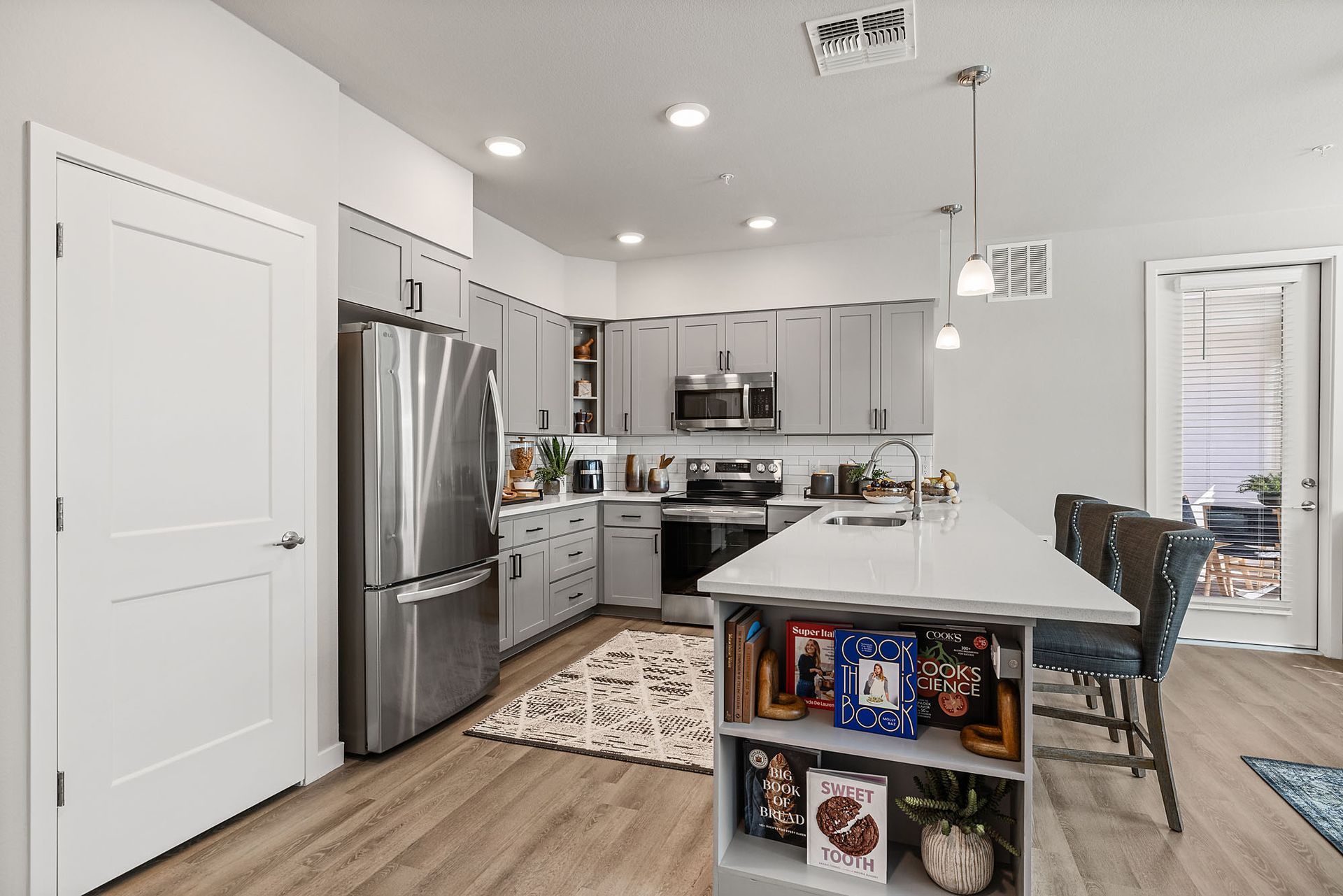 Modern kitchen with grey cabinets, stainless steel appliances, and a white island at Marq Bronco Butte, offers  apartments in North Phoenix, AZ.