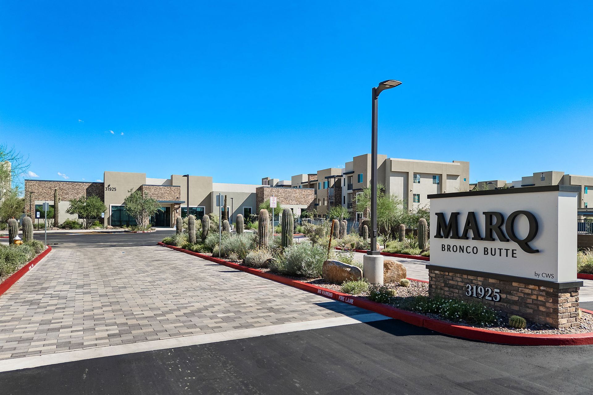 Entrance to MARQ at Kierland luxury apartments with sign, landscaping, and blue sky at Marq Bronco Butte, offers  1, 2, and 3 bedroom apartments in North Phoenix, AZ, with EV charging stations.