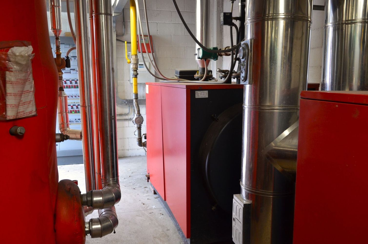 Unità di riscaldamento HVAC rosse e condotti lucidi in un locale tecnico