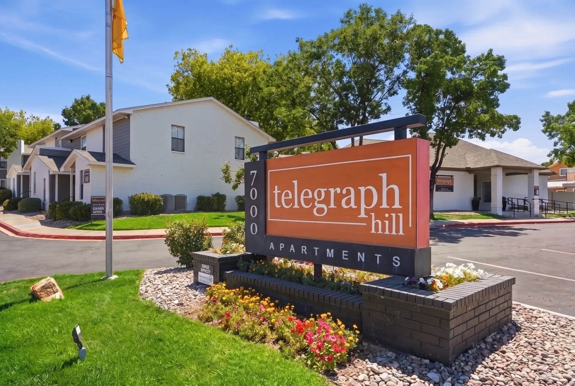 Telegraph Hill Apartments monument sign with landscaping and apartment buildings in background.