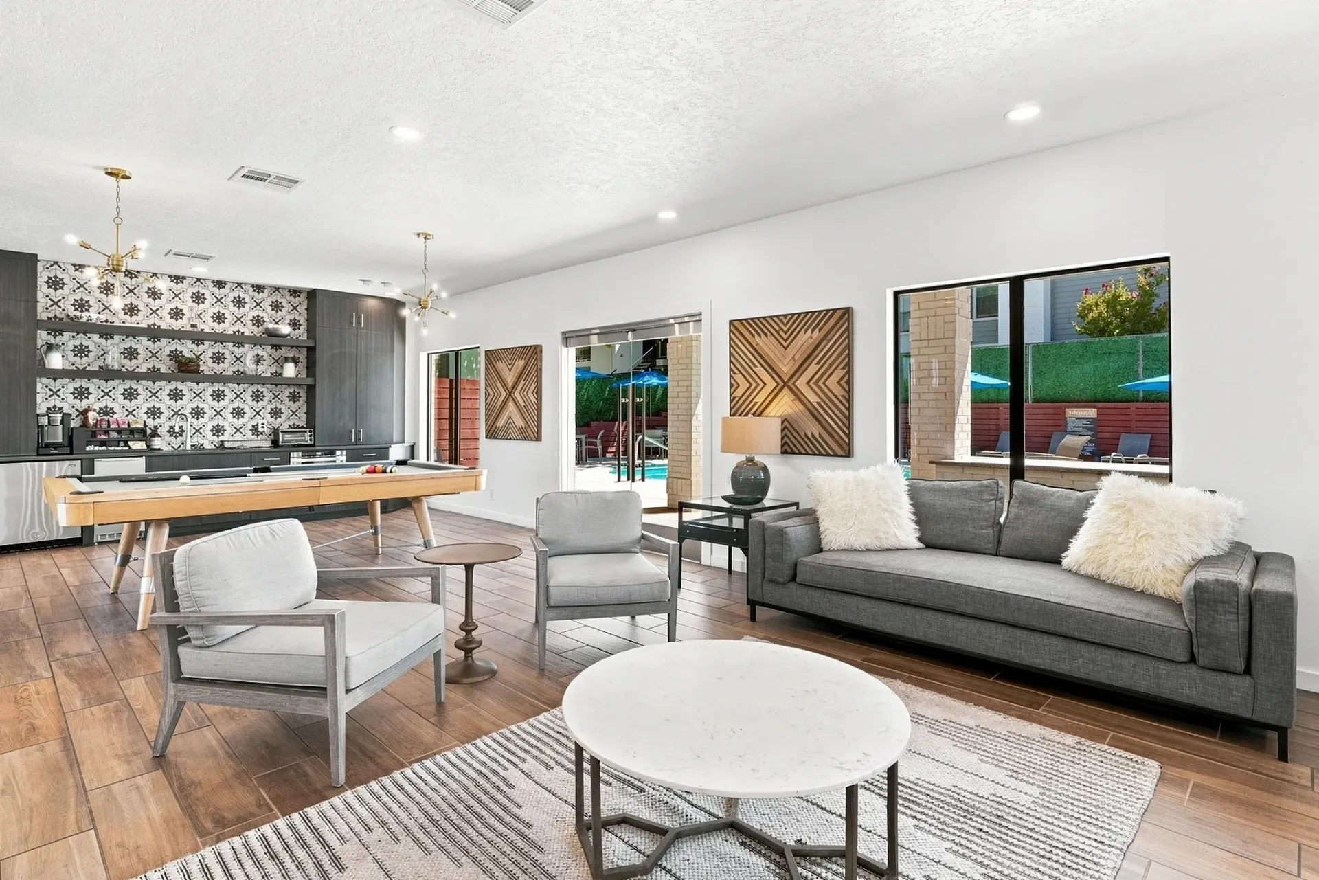 Community lounge with a pool table, seating area, and view of the outdoor pool.
