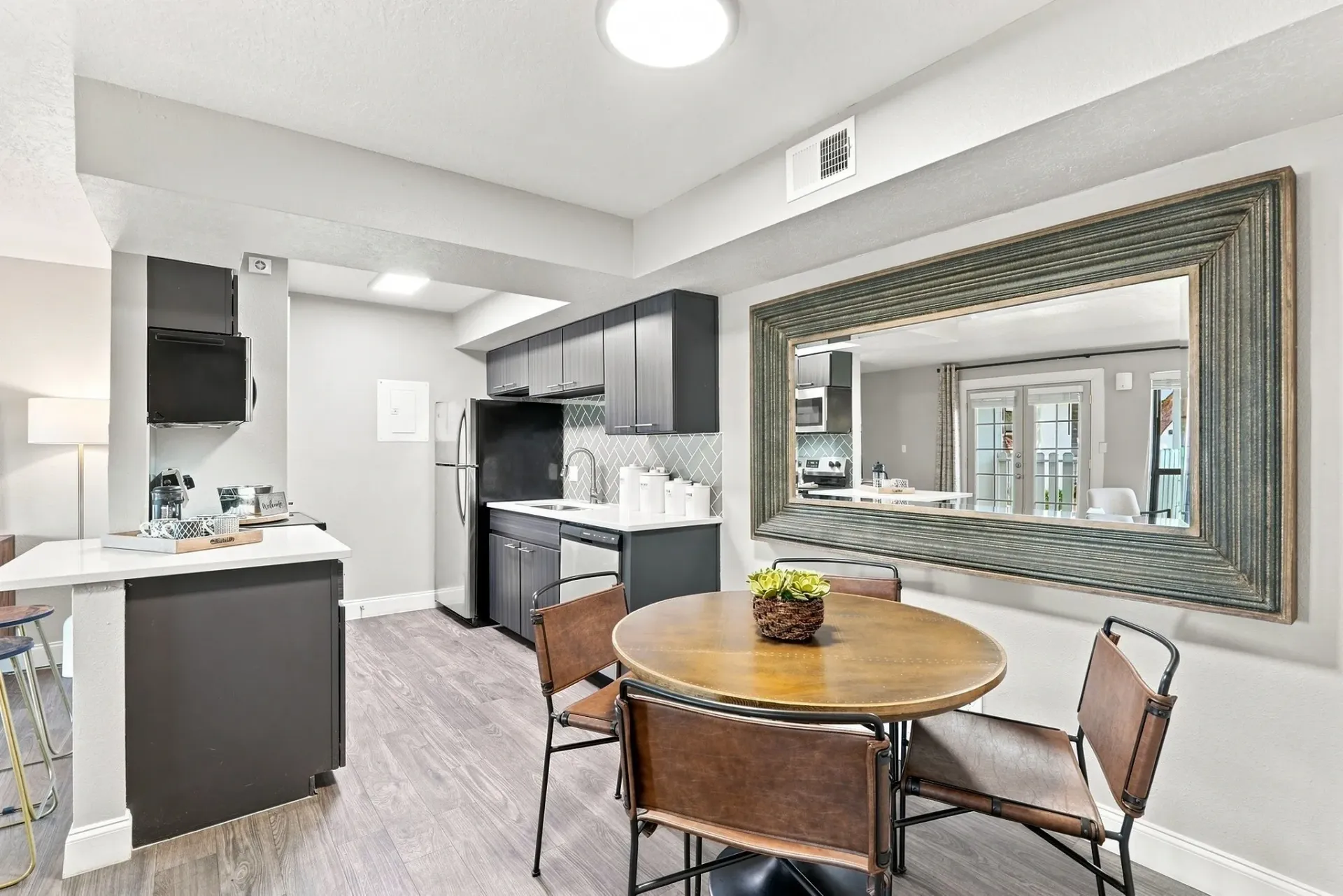 Modern kitchen and dining area with stainless steel appliances and a round dining table.