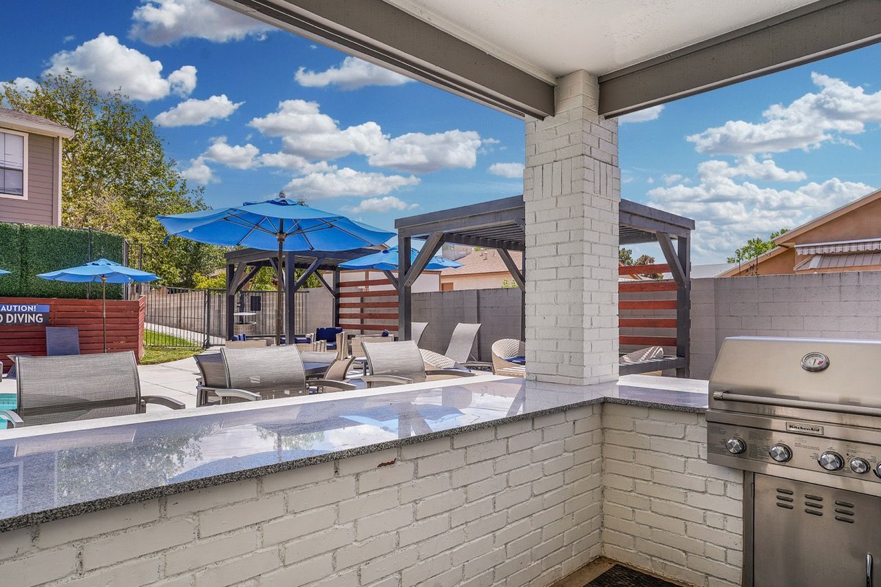 Telegraph Hill community amenity area with grills, loungers, and blue umbrellas.