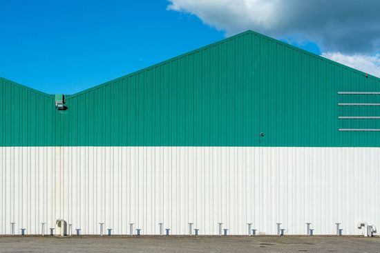 Large green-and-white commercial building under a blue sky