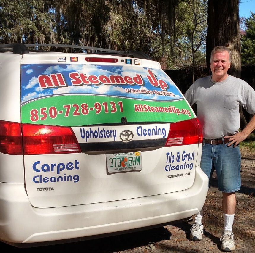 Man stands next to a white van with business name 