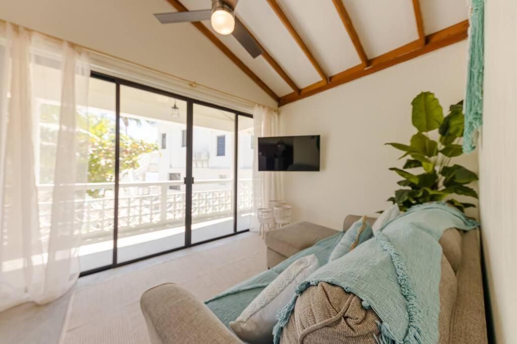 Living room with sofa, TV, and sliding glass doors to balcony.