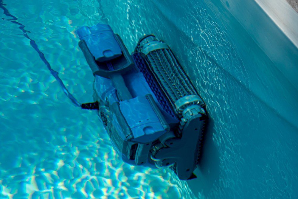 A Robotic Pool Cleaner is Cleaning the Side of a Swimming Pool — Tweed Coast Pool Care in Tweed Heads, NSW