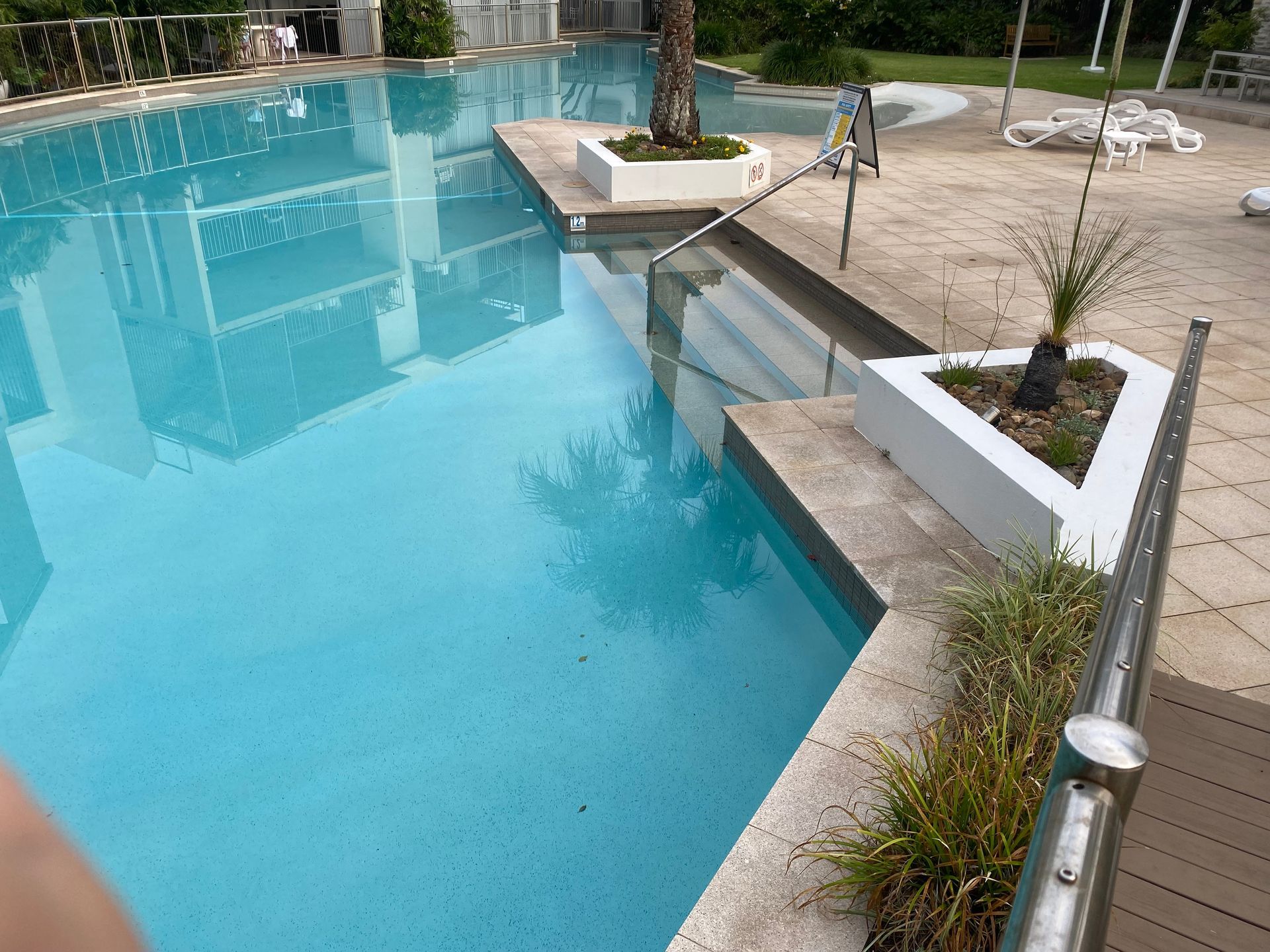 A Man is Cleaning a Swimming Pool With a Robotic Vacuum Cleaner — Tweed Coast Pool Care in South Murwillumbah, NSW