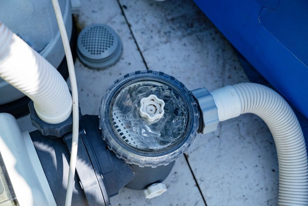 A Person is Working on a Swimming Pool Filter — Tweed Coast Pool Care in Tweed Heads, NSW