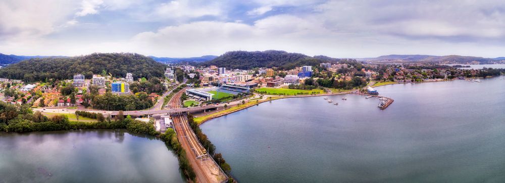 An Aerial View Of A Bridge Over A Body Of Water With A City — CJ Electrical & Solar In Gosford, NSW