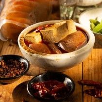 A bowl of food is sitting on top of a wooden table.