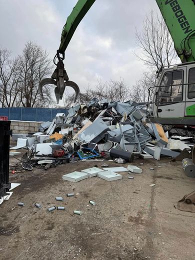 A trailer overflowing with construction debris, including wood and other materials, parked outdoors.