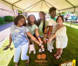 A group of people are posing for a picture under a tent.