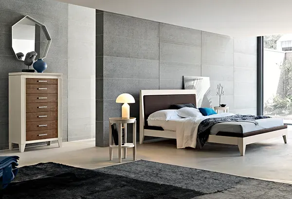 Una camera da letto con un letto, una cassettiera e uno specchio