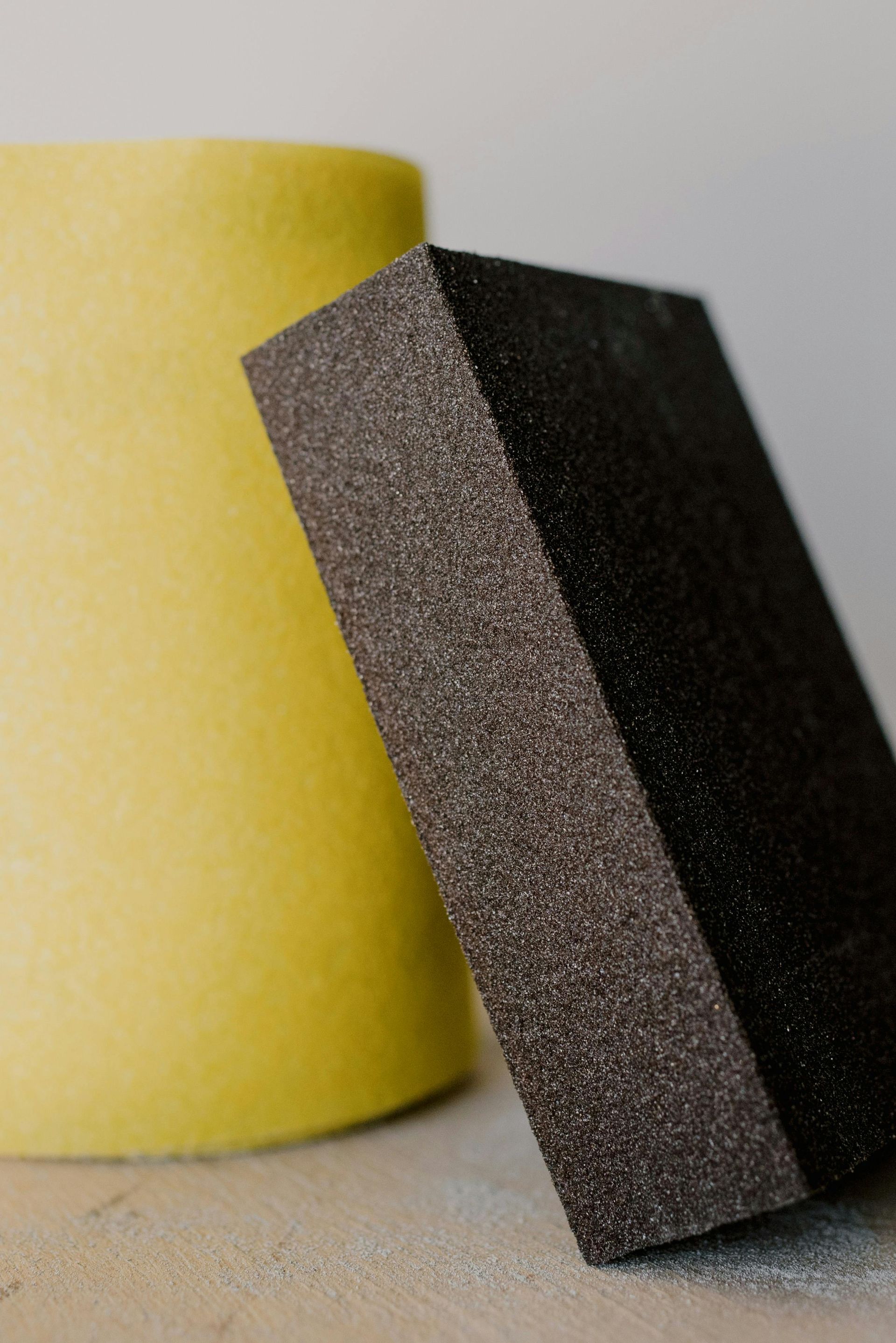 Two sanding blocks are sitting next to each other on a table.
