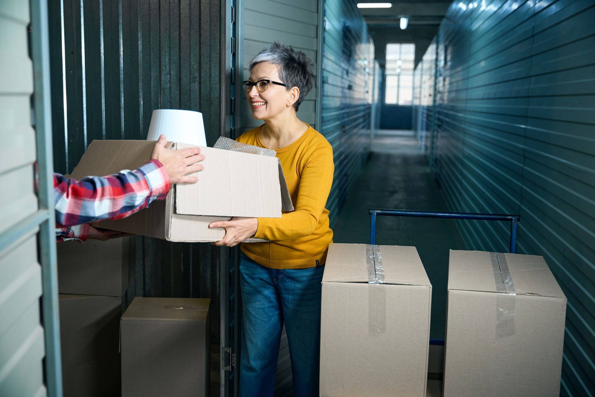 Woman unloading boxes inside indoor self-storage facility in Juneau, Alaska.