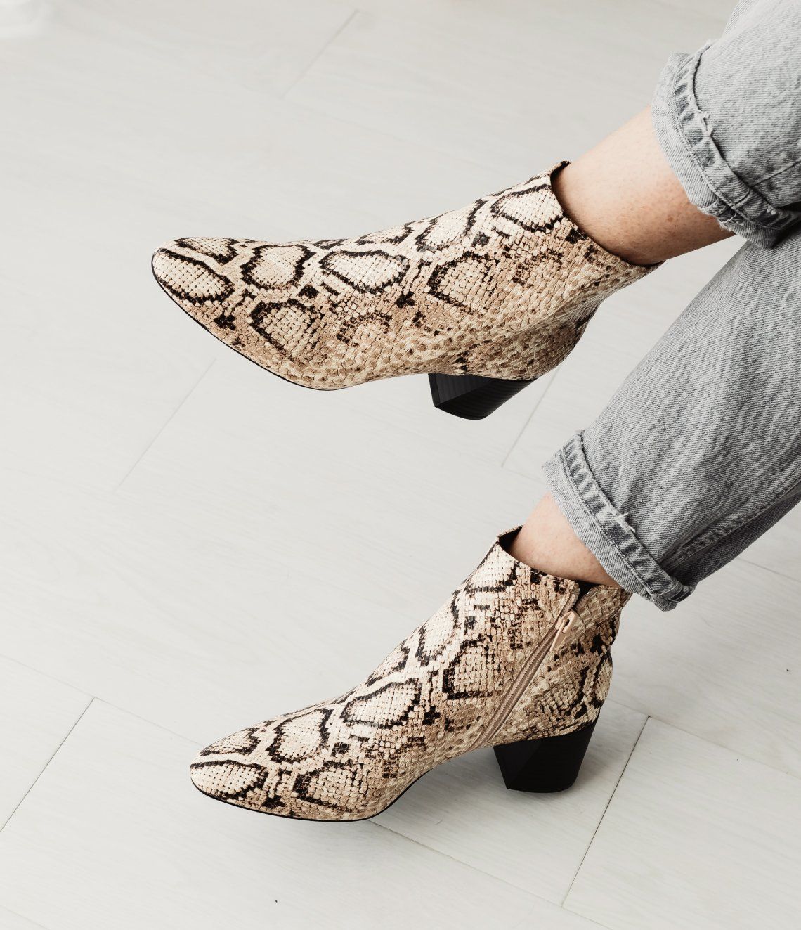 A person wearing a pair of snake print boots