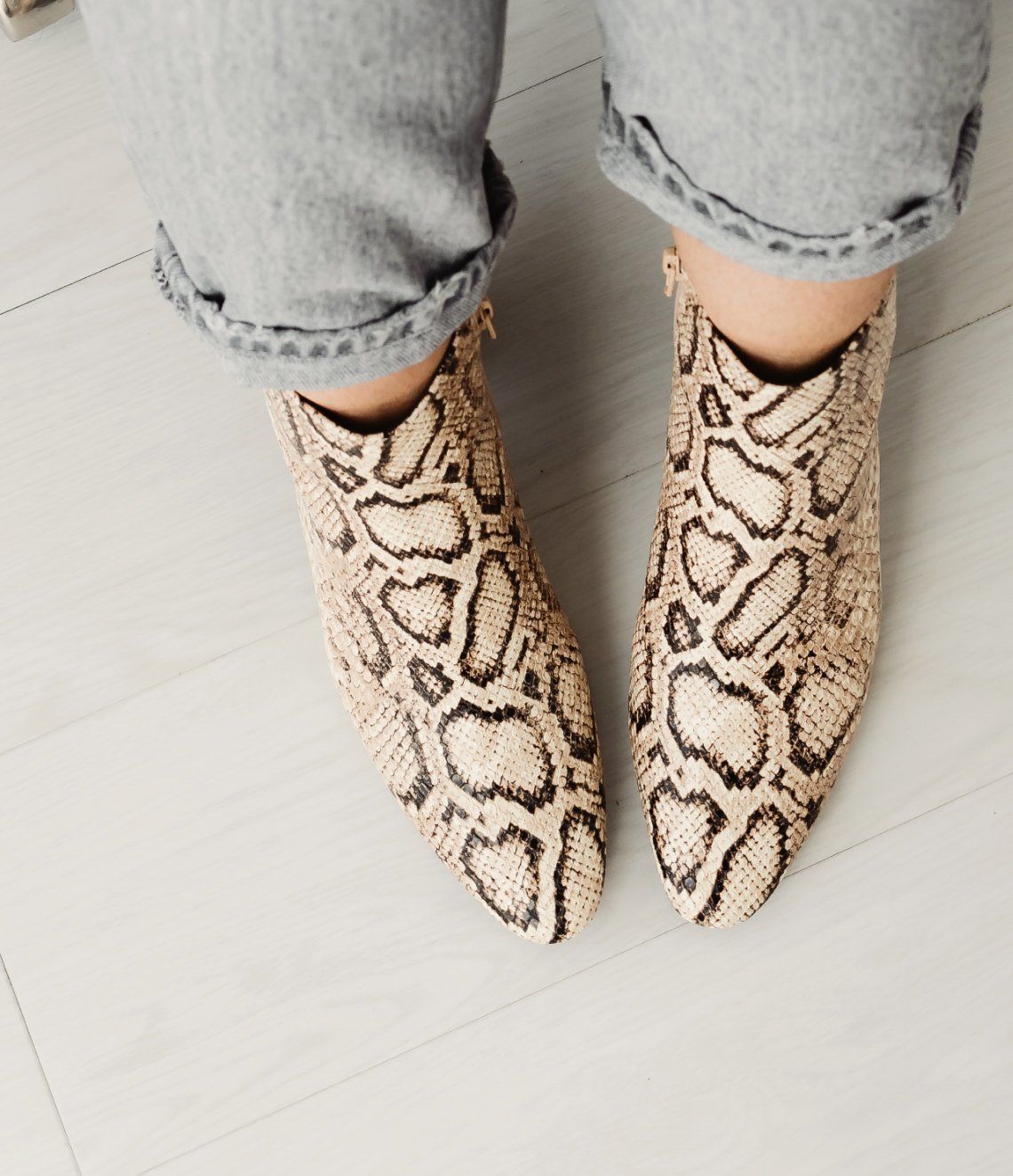 A person wearing a pair of snake print boots