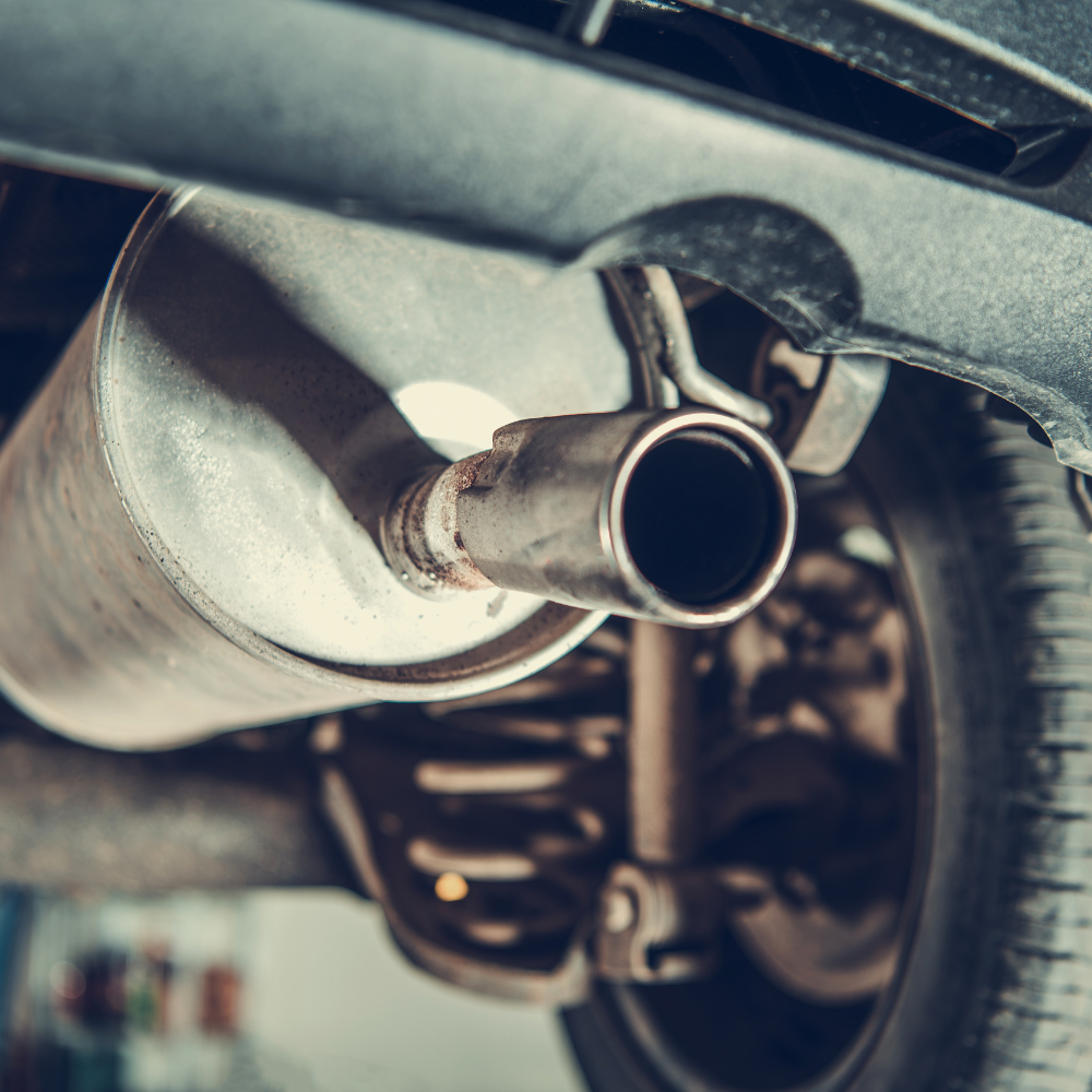 Close-up of a car’s exhaust pipe and muffler underneath the vehicle.