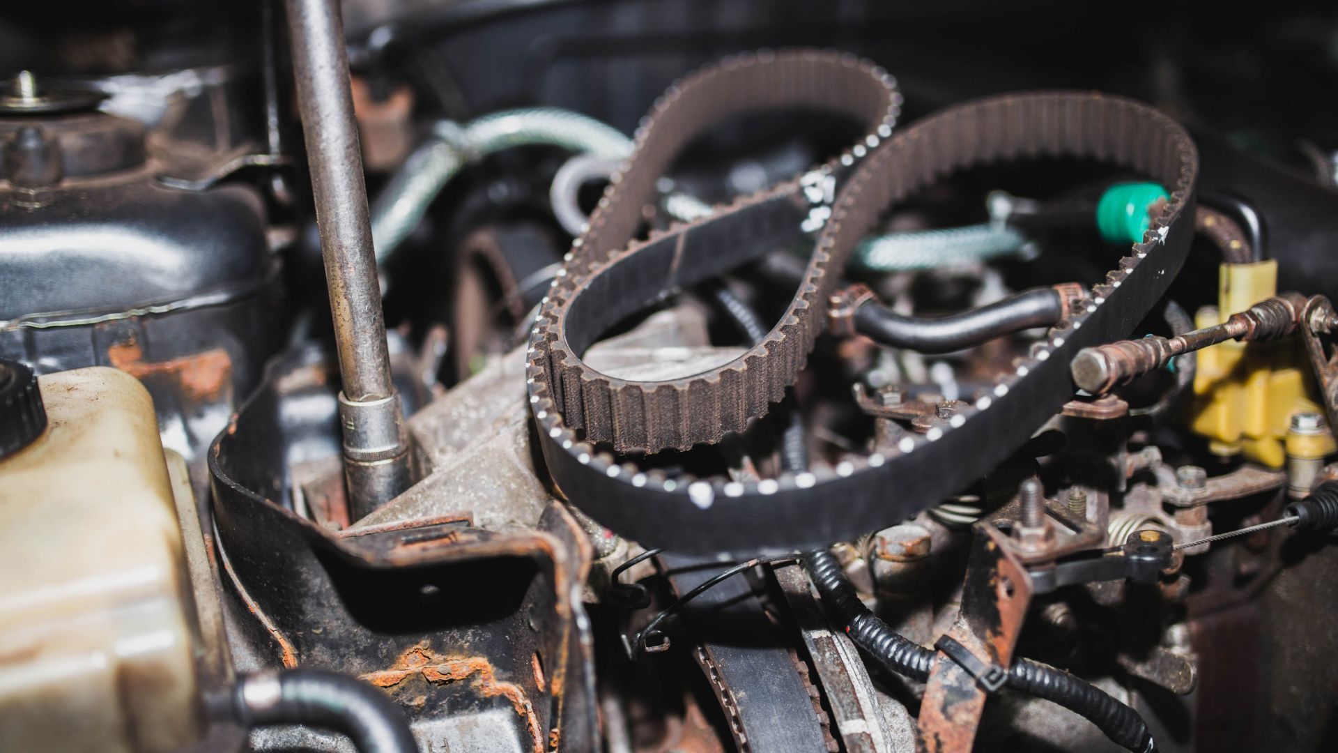 Close-up of a car engine with exposed timing belt and pulleys during repair
