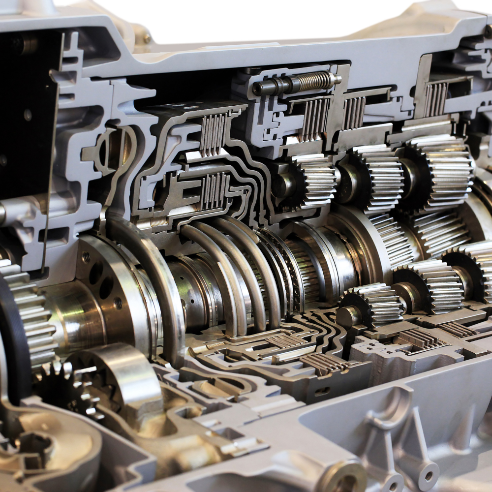 Cutaway view of a metal gearbox showing interlocking gears and shafts inside a transmission casing