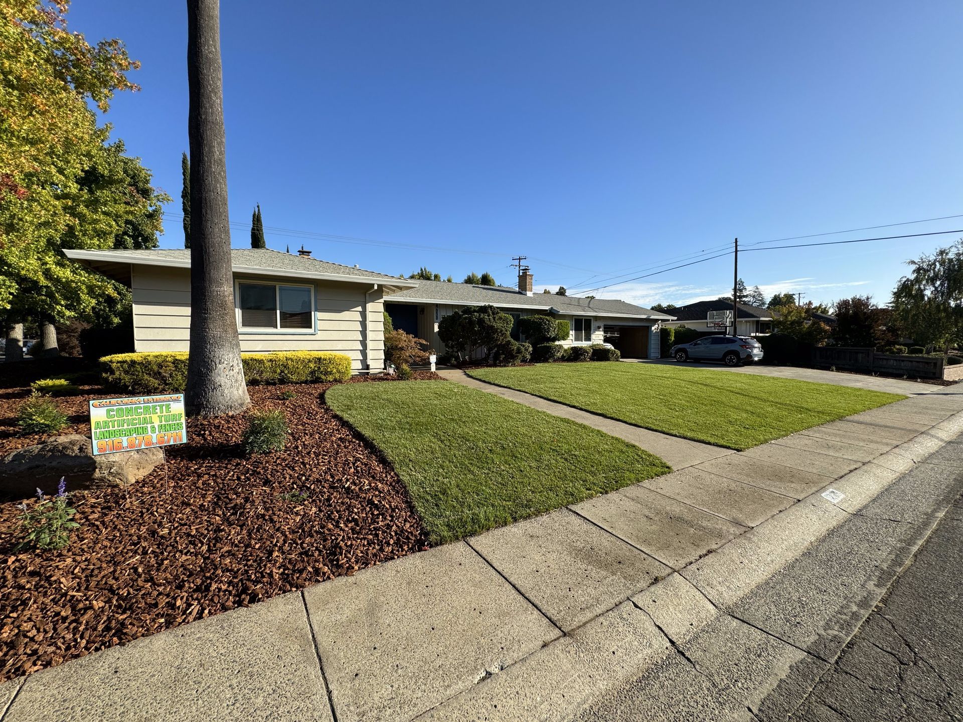 A house with a lot of grass and a sidewalk in front of it