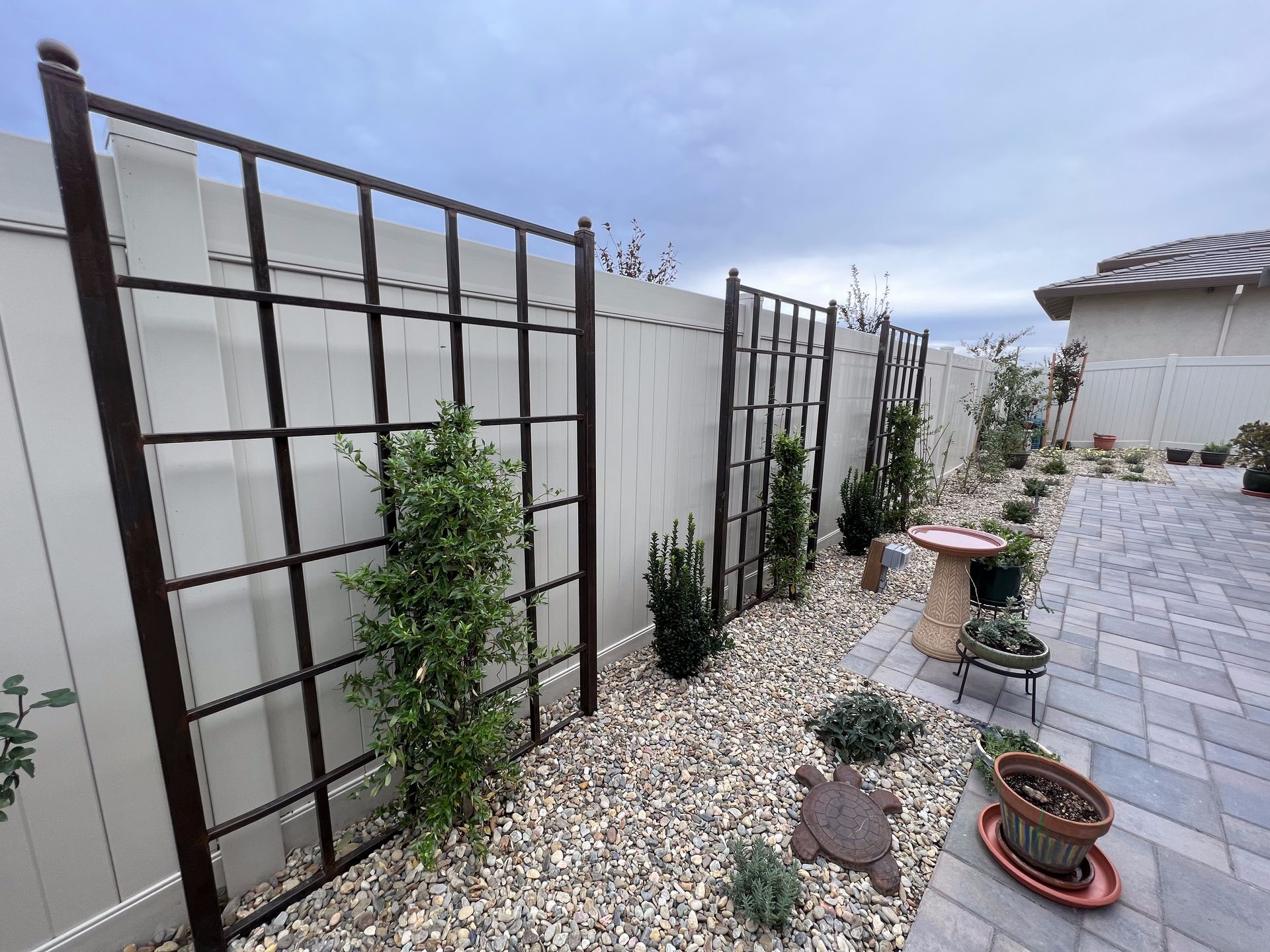 A fence with a trellis in the backyard of a house