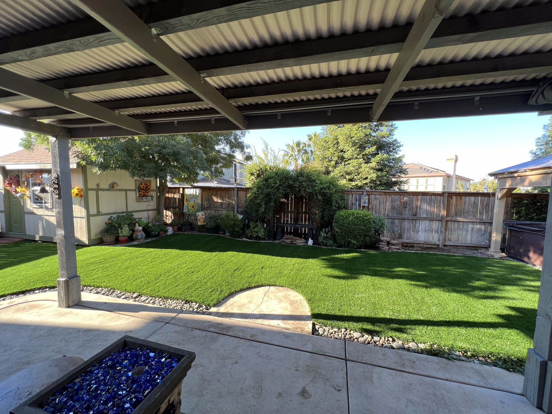 A backyard with a covered patio and a fire pit.