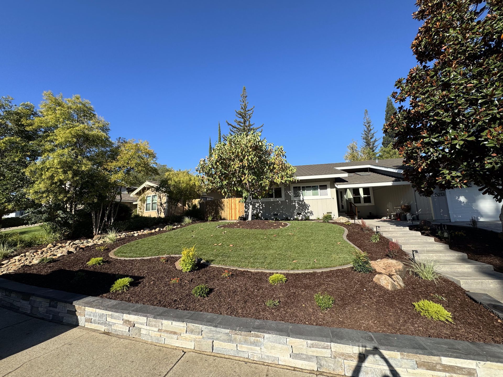 A house with a large lawn and trees in front of it
