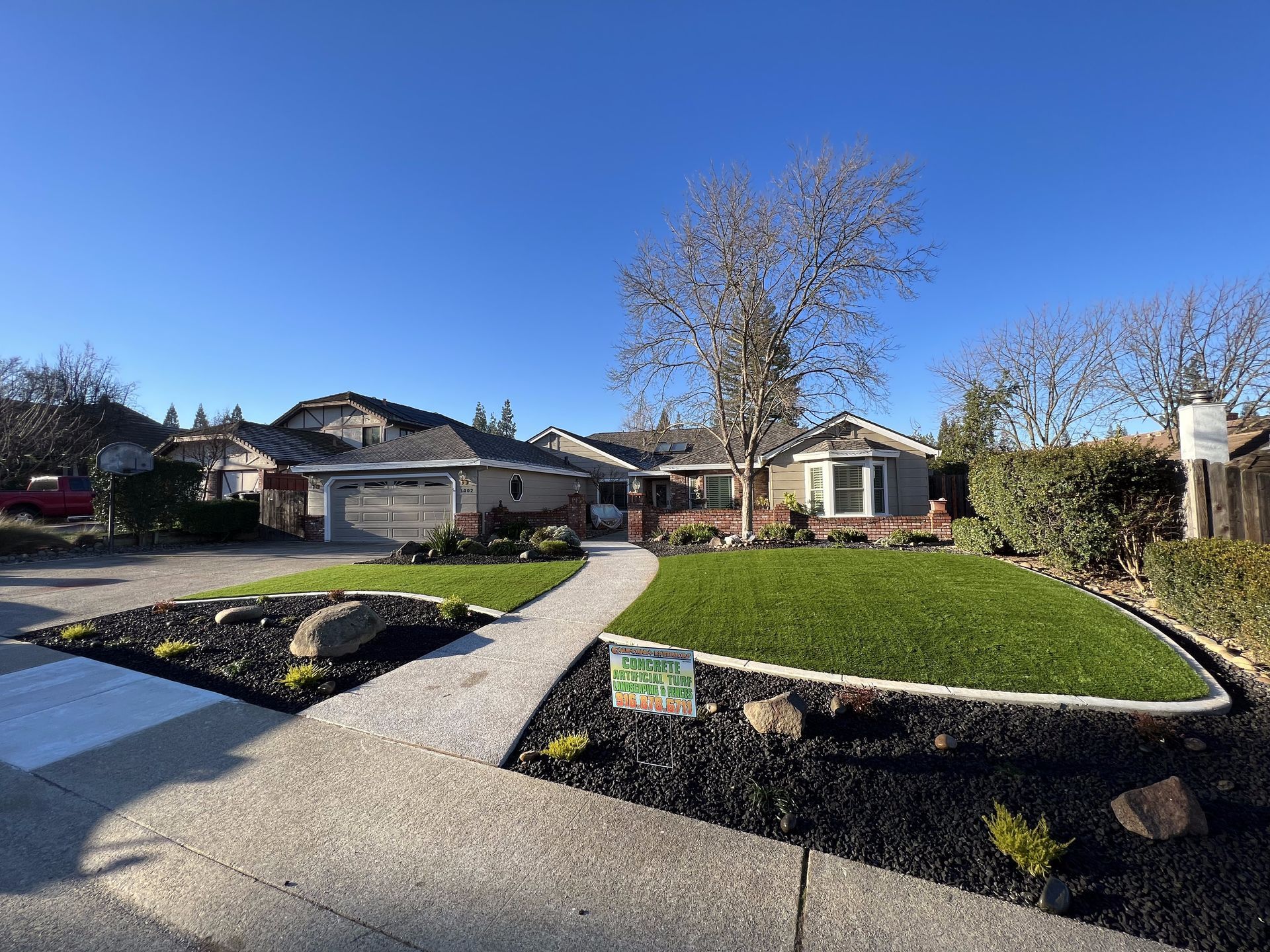 A house with a lush green lawn and a walkway leading to it.