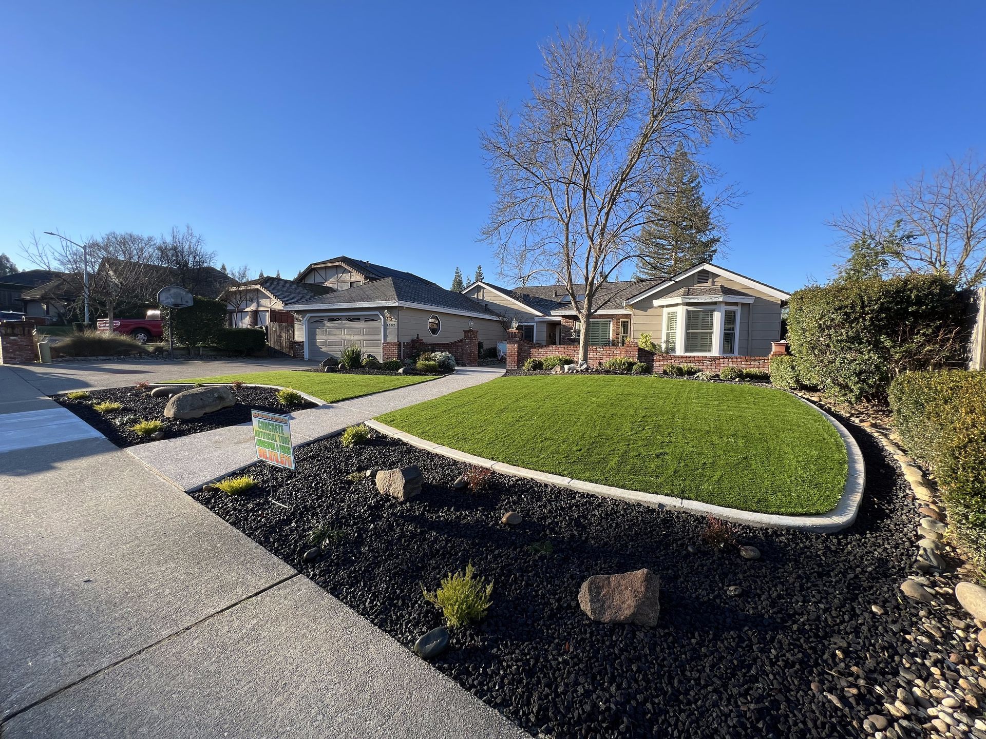 A house with a lush green lawn and a sidewalk in front of it.