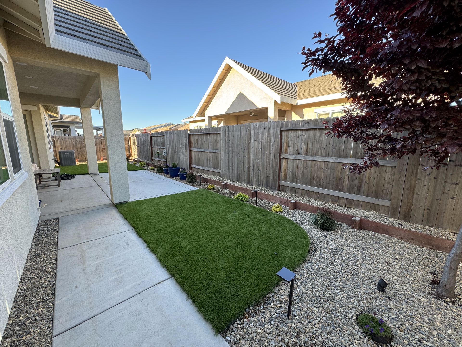A house with a wooden fence and a lush green lawn