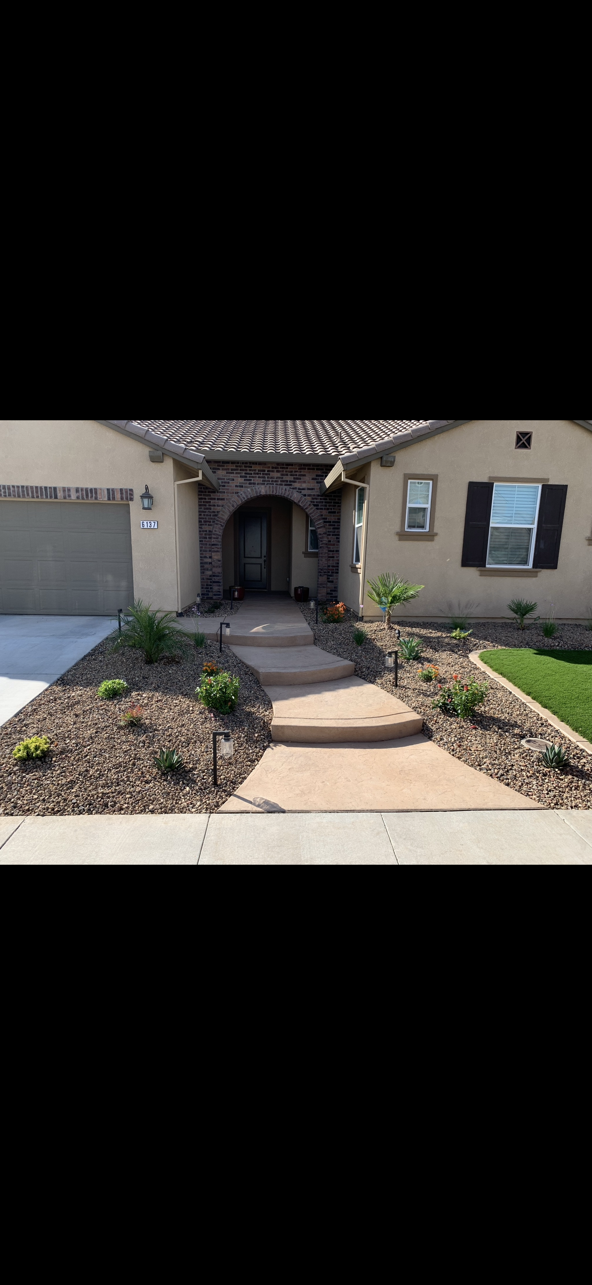 A house with a walkway leading to the front door and a garage.