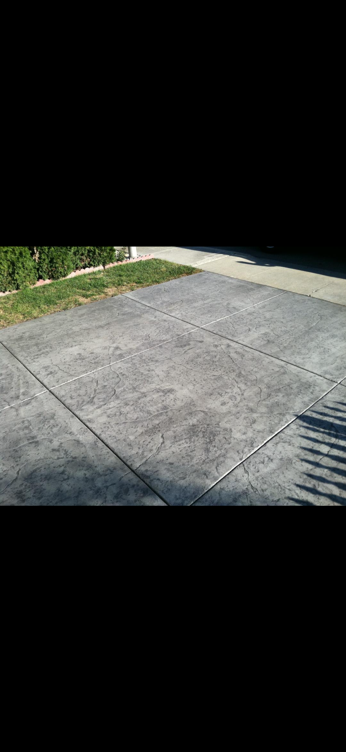A concrete driveway with a shadow of a person on it.