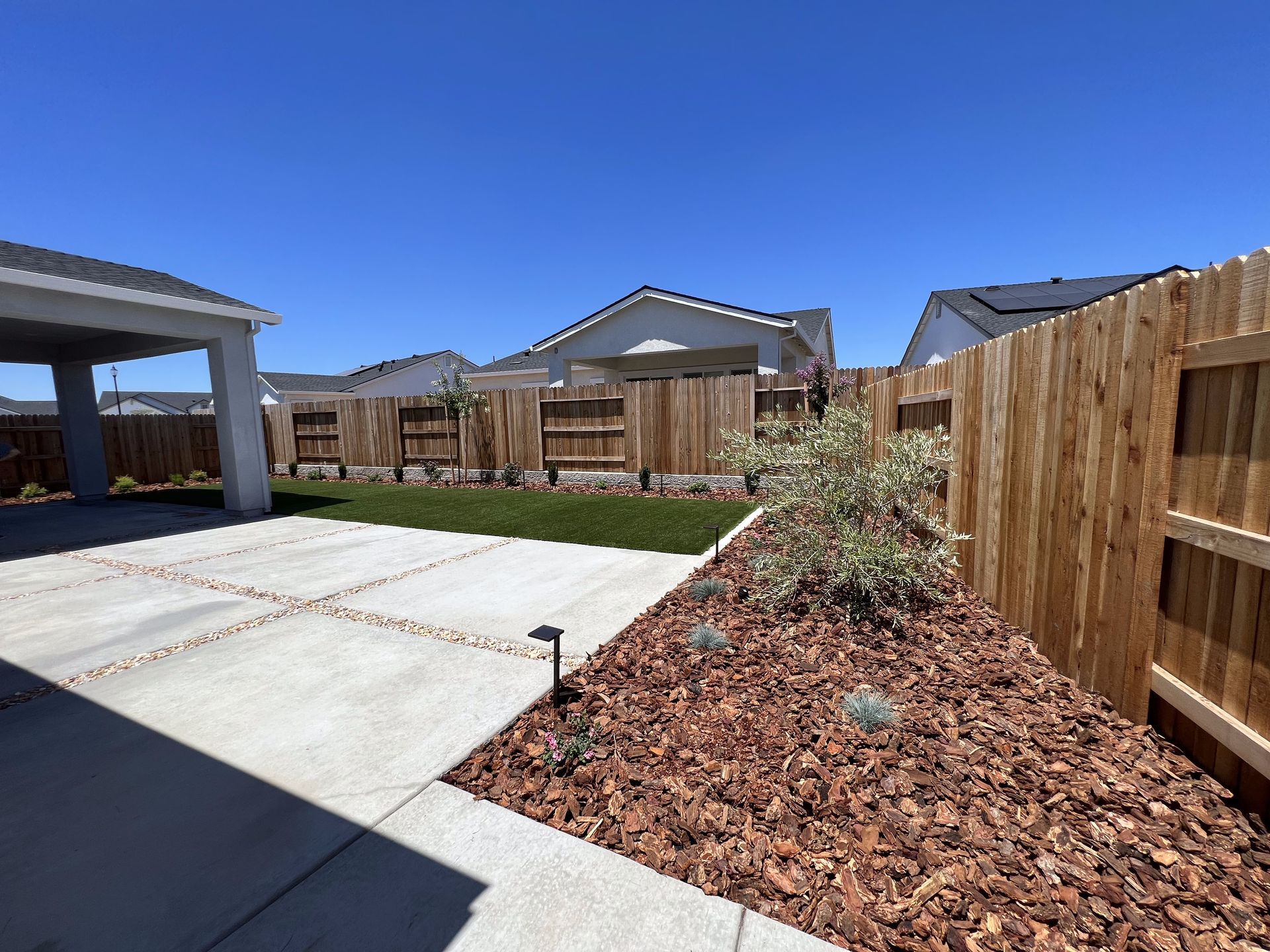 There is a wooden fence in the backyard of a house.