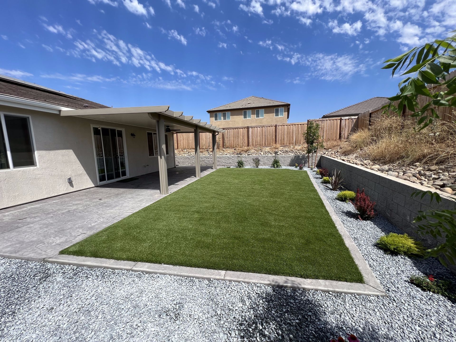 A backyard with a large lawn and a house in the background.