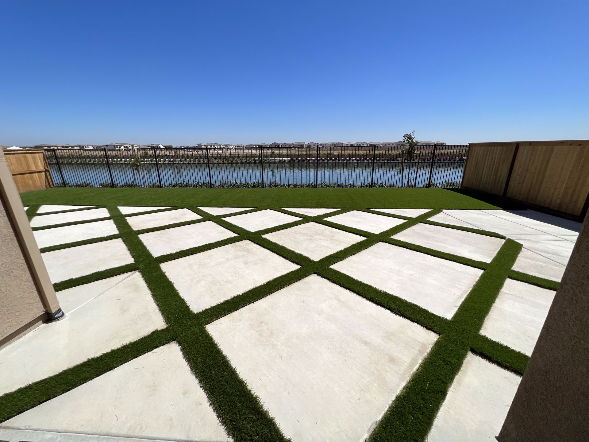 A patio with a view of a body of water and a fence.